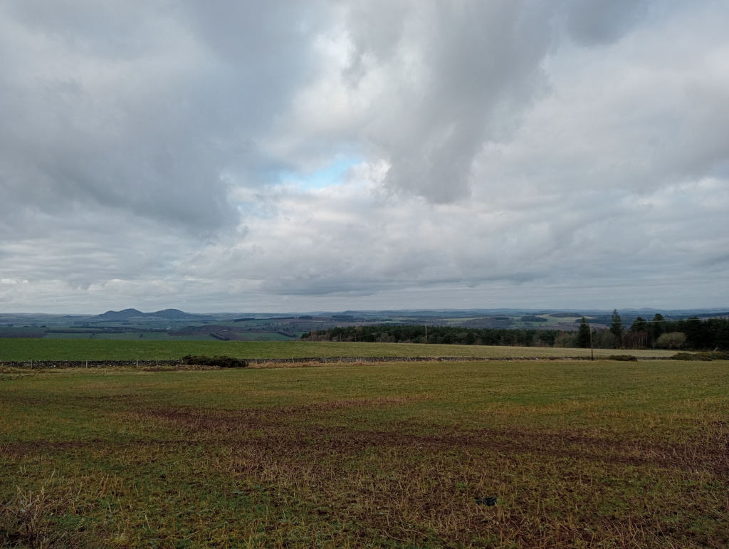 To the left are the Eildon Hills, beyond are Scottish border towns of Melrose and Galashiels.