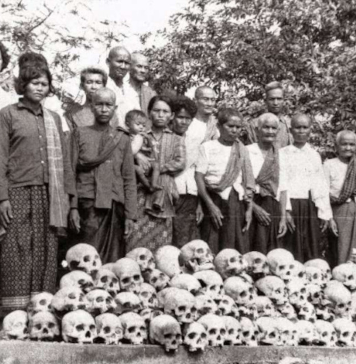 Clergymen and monks conducting a Buddhist religious ceremony in front of the skulls of those who died during the Khmer Rouge regime