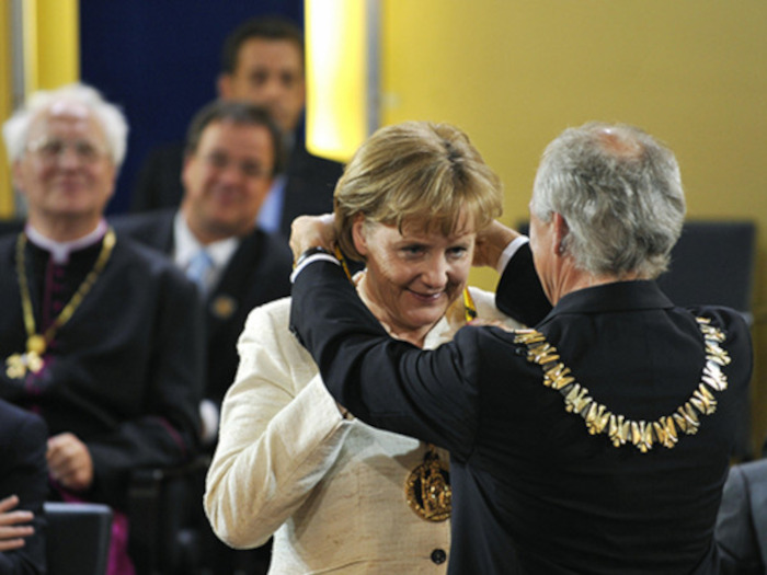 Angela Merkel, the German Chancellor, receives the Charlemagne Prize from Juergen Linden