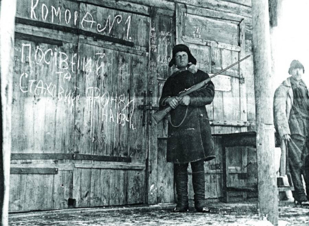 An armed guard stands in front of the grain warehouse, ready to shoot anyone who tries to steal the food inside. USSR. Circa 1934