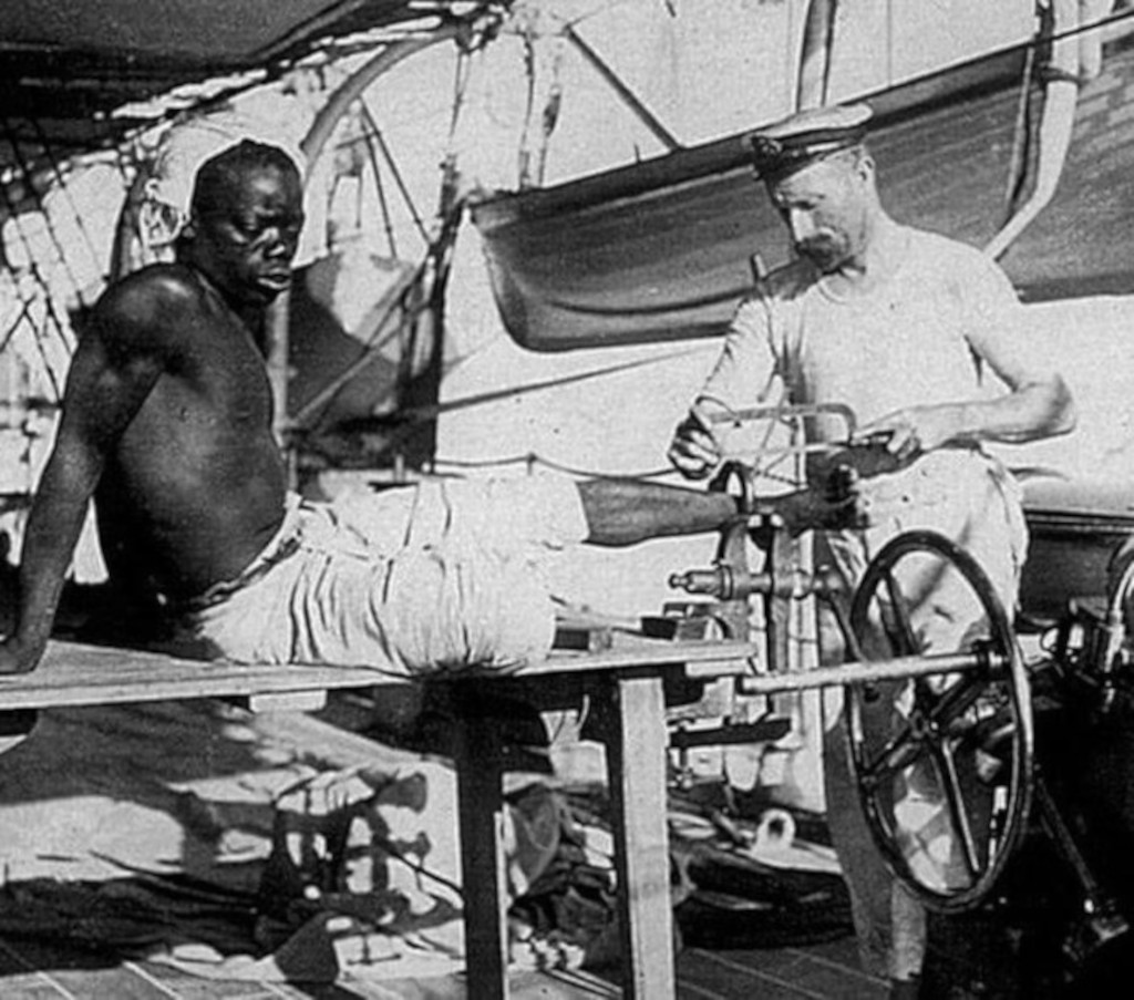 British blacksmith removing leg irons from slave off the coast of Oman, 1907
