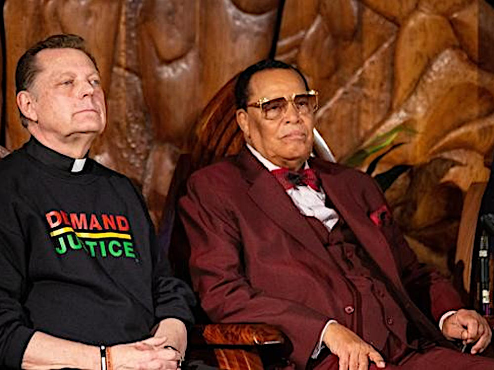 American Catholic priest and social activist Michael Pfleger seated with Nation of Islam's Louis Farrakhan. Pfleger is wearing a sweatshirt coloured with N.O.I story of Yakub, embelemed with the words Demand Justice