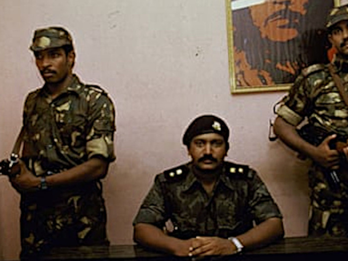 Prabhakaran delivering a Cominique, behind hanging picture of Argentine Marxist Che Guevara