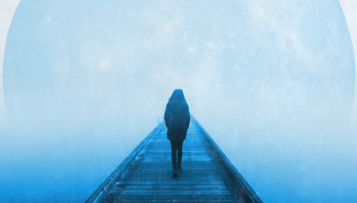 A lone woman walks along a pier into a mist before an open sea